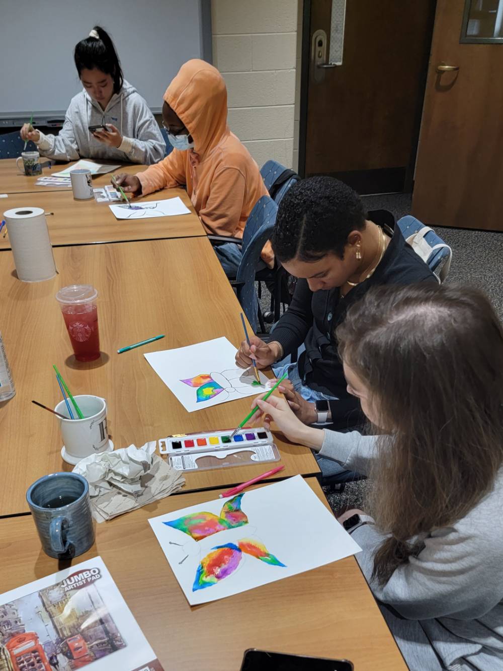 conversation club memebers painting with water colors